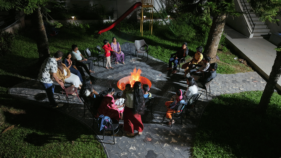 A bonfire set up made in an outdoor space with people enjoying by it. | WOW Naturefull Resorts, Yercaud