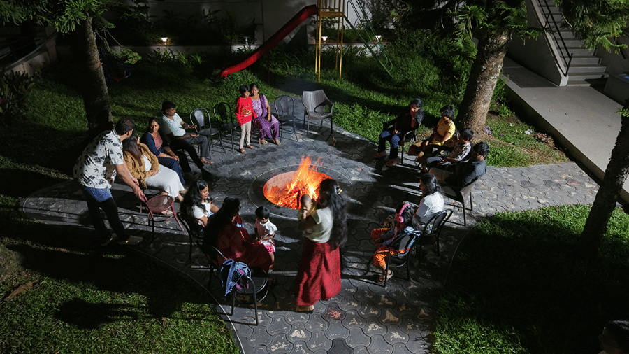 A bonfire set up made in an outdoor space with people enjoying by it. | WOW Naturefull Resorts, Yercaud