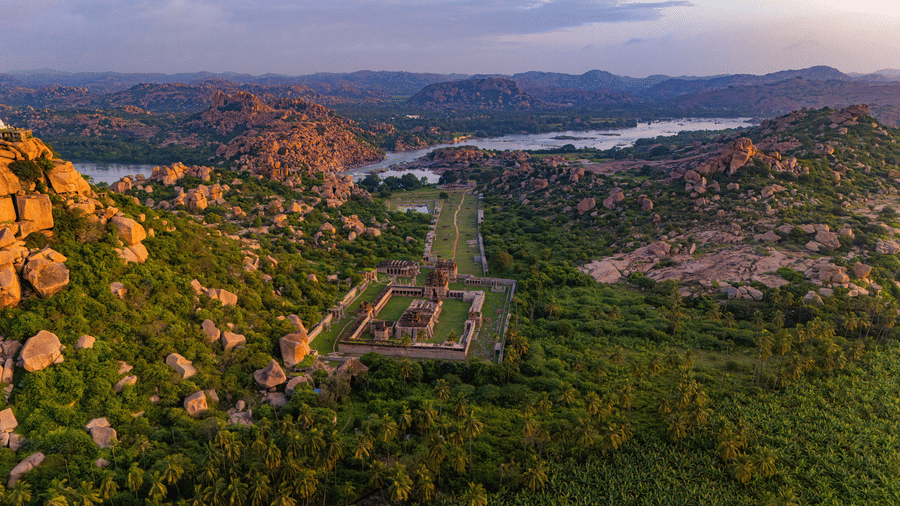 Aerial view of Hampi ruins with lake and wildflowers near Evolve Back resort