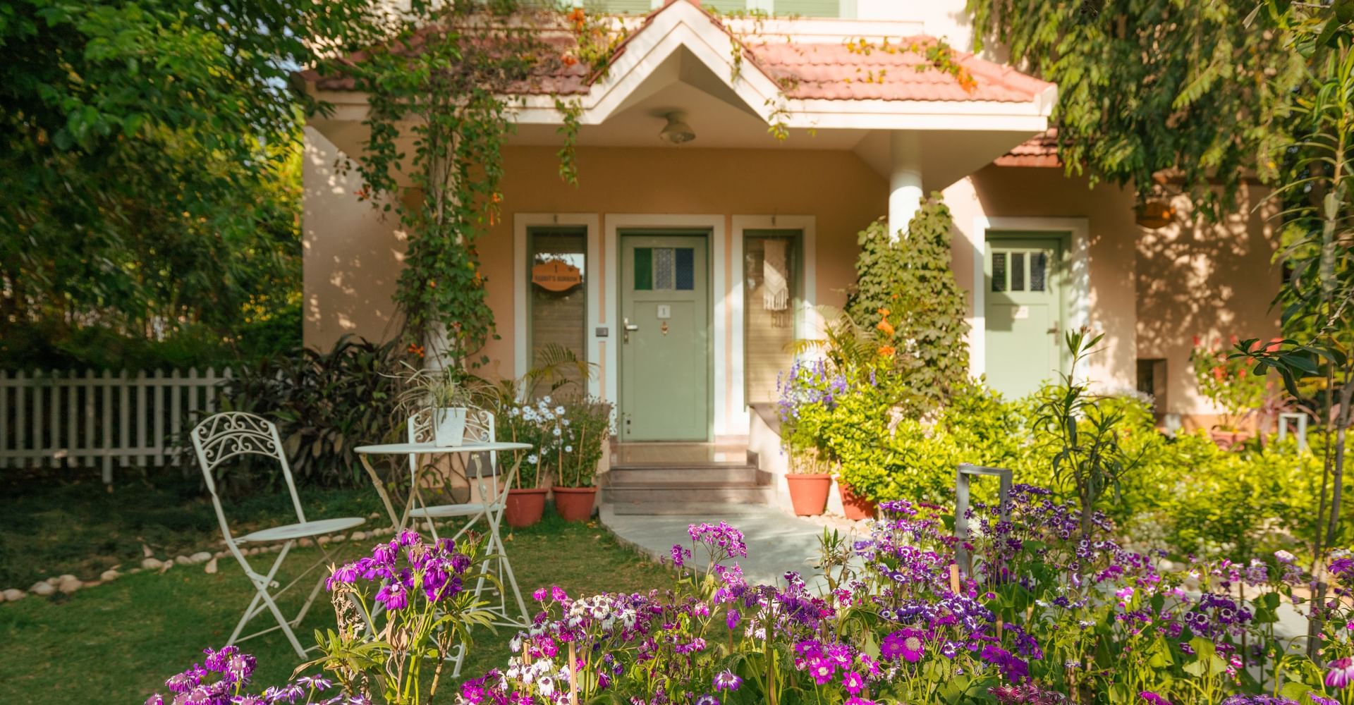 Charming garden seating area surrounded by flowers and greenery at Karma Chalets.