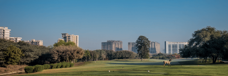 An overview of the golf course with buildings and trees in the background at Karma Lakelands
