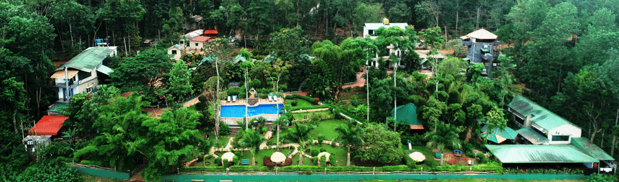 Aerial view of Coorg Jungle Camp Backwater Resort, Kushalnagar surround by lush greenery.