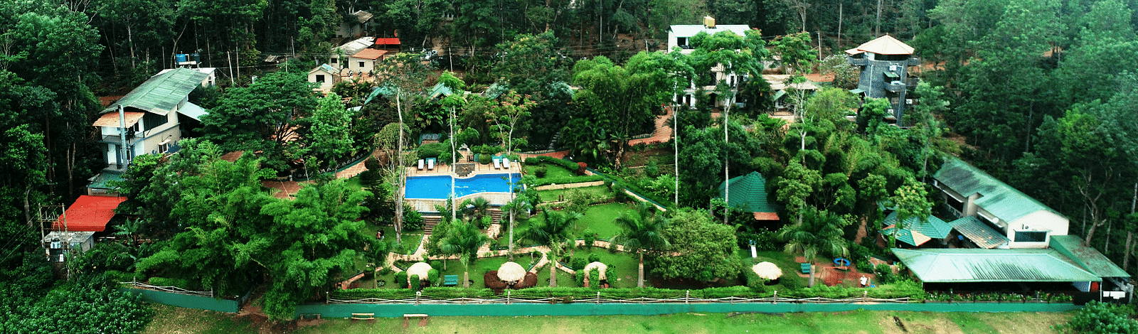 Aerial view of Coorg Jungle Camp Backwater Resort, Kushalnagar surround by lush greenery.
