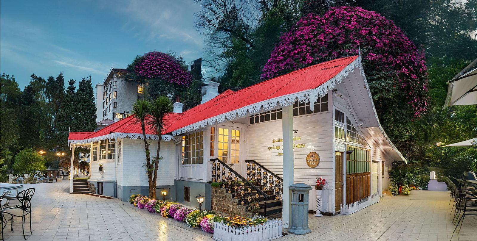 Facade of Summit Swiss Heritage Resort & Spa, Mall Road with trees in the background.