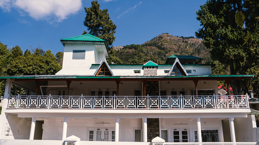 Facade of BluSalzz Villas - The Green Roof, Bhimtal, is set against a stunning backdrop of mountains and lush trees.