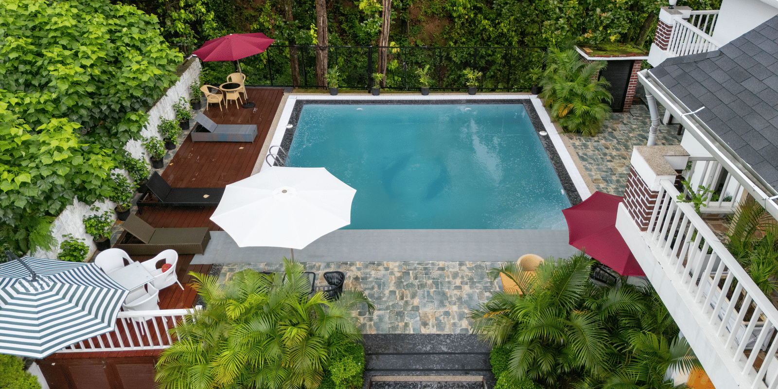 Outdoor swimming pool with greenery around at Megha Resort & Villas, Dehradun.