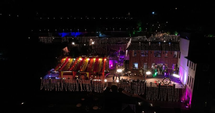 Nighttime event showcases an illuminated outdoor setup with vibrant colourful lights enhancing the decorations - Digantaa Resort in Mukteshwar