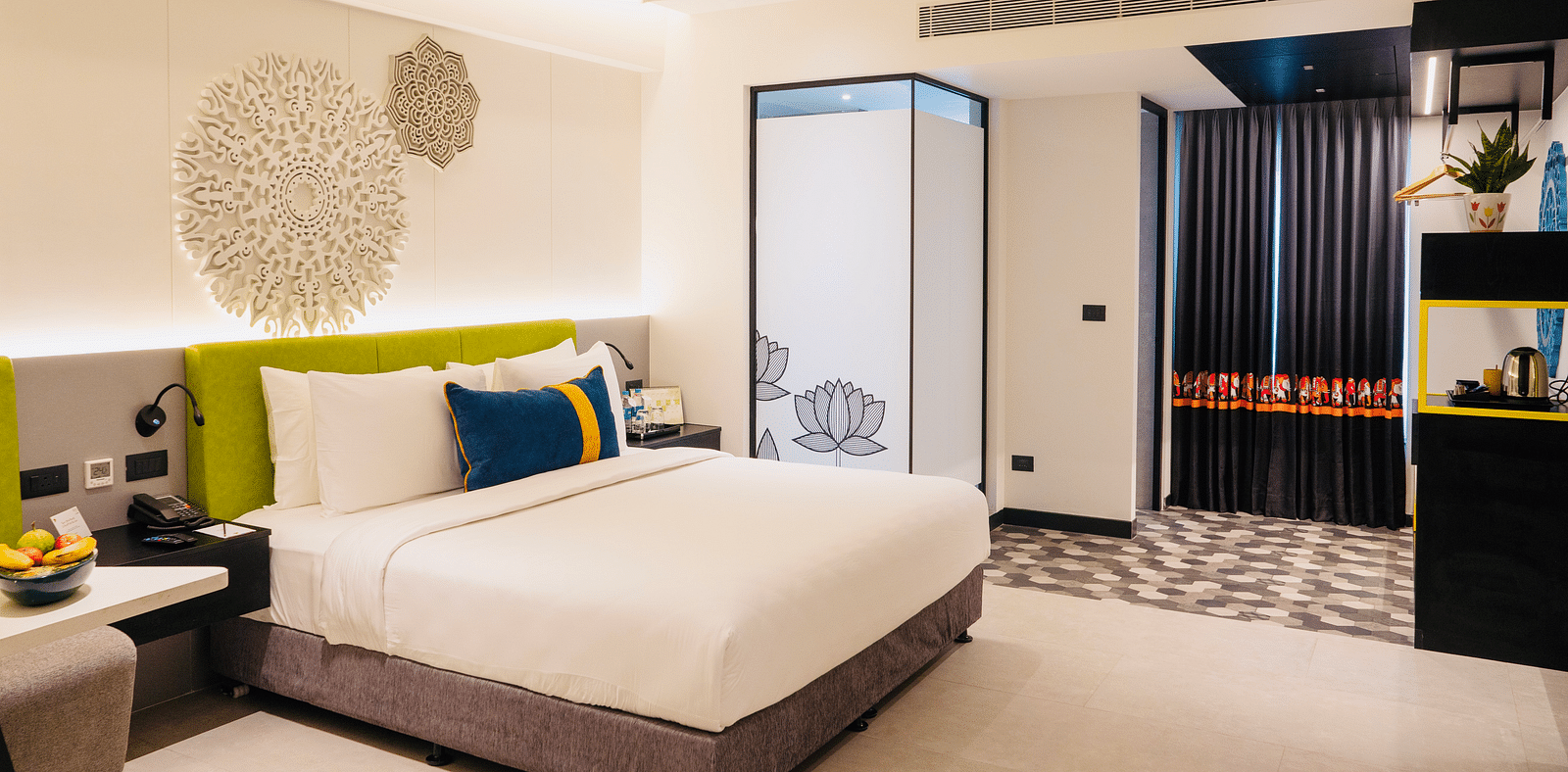 An image of a bedroom showcasing a sculptured headboard at Zibe Luxe Kakinada by GRT Hotels