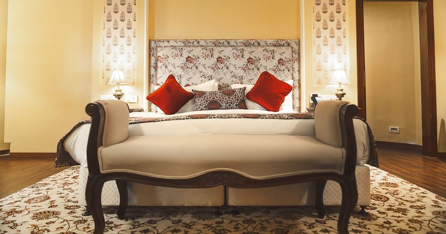 The majestic king sized bed with red sleeping pillows at the Super deluxe room at The Garden Ananta Elite.