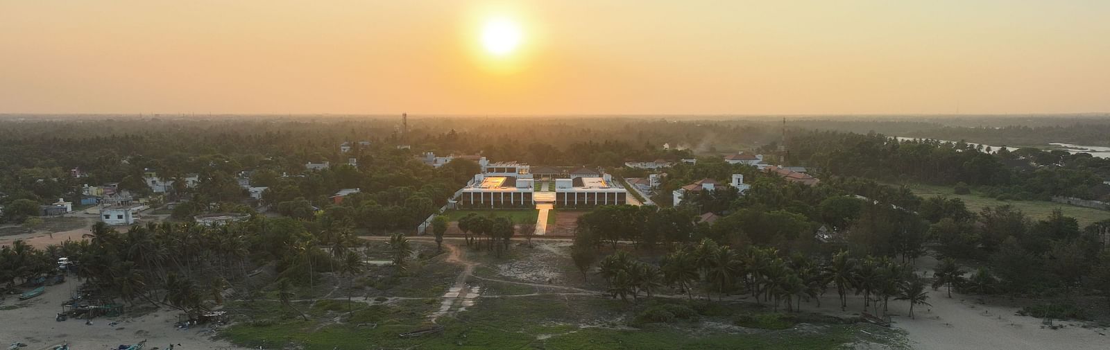 Facade image of the resort with the ocean waves crashing the beach shoreline at The Shore Trishvam, Pondicherry.