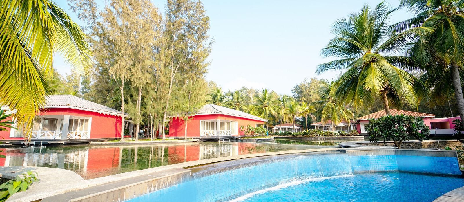 Swimming Pool with two red houses on the side with trees on the side - Ocean Spray, Puducherry