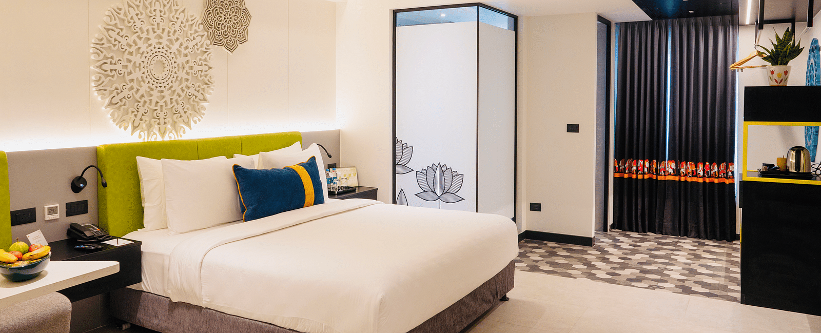 An image of a bedroom showcasing a sculptured headboard at Zibe Luxe Kakinada by GRT Hotels