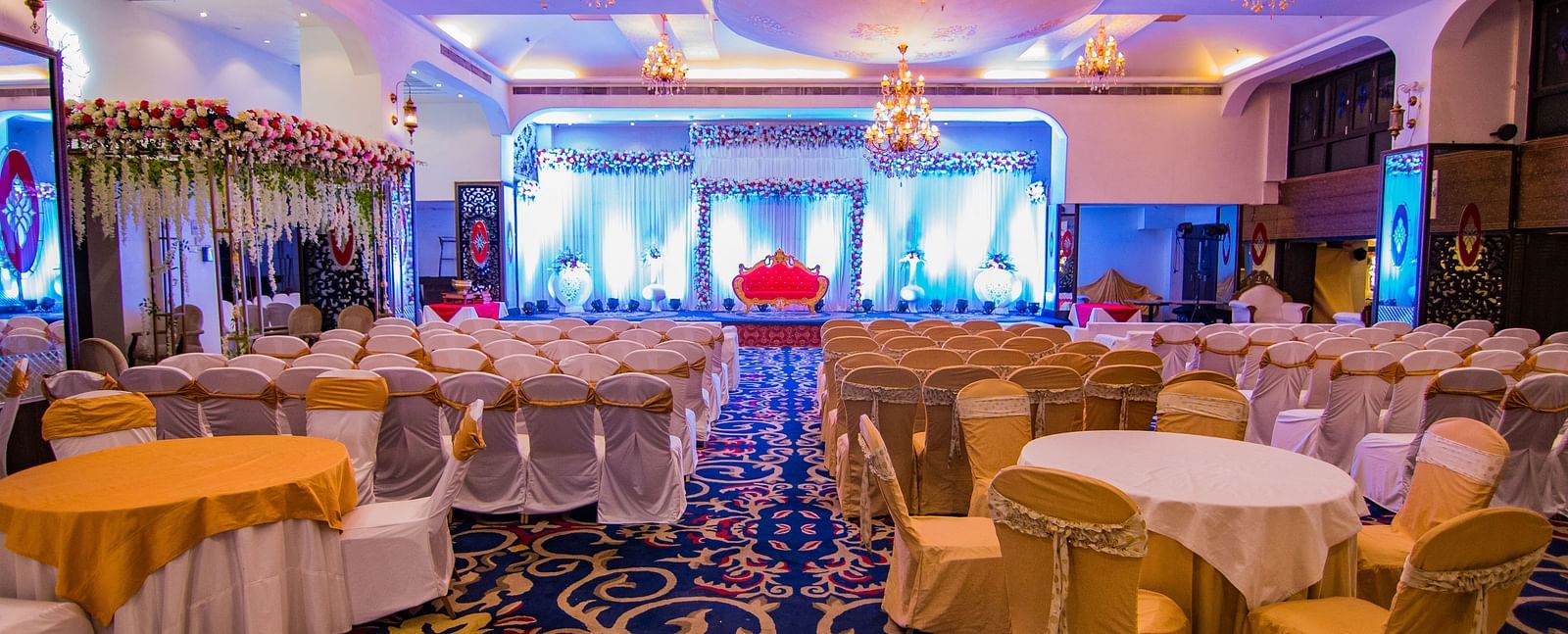Kohinoor showcasing the stage backdrop and round tables with ambient lighting.