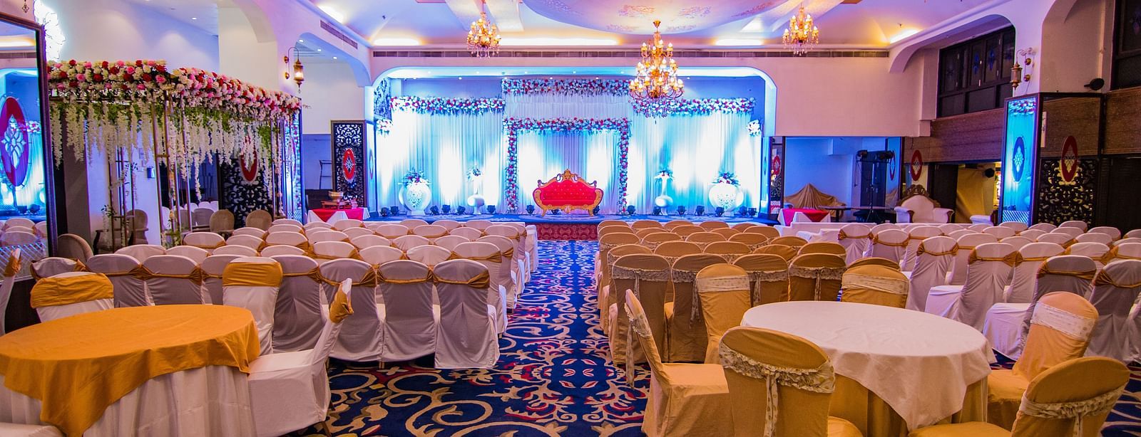 Kohinoor showcasing the stage backdrop and round tables with ambient lighting.