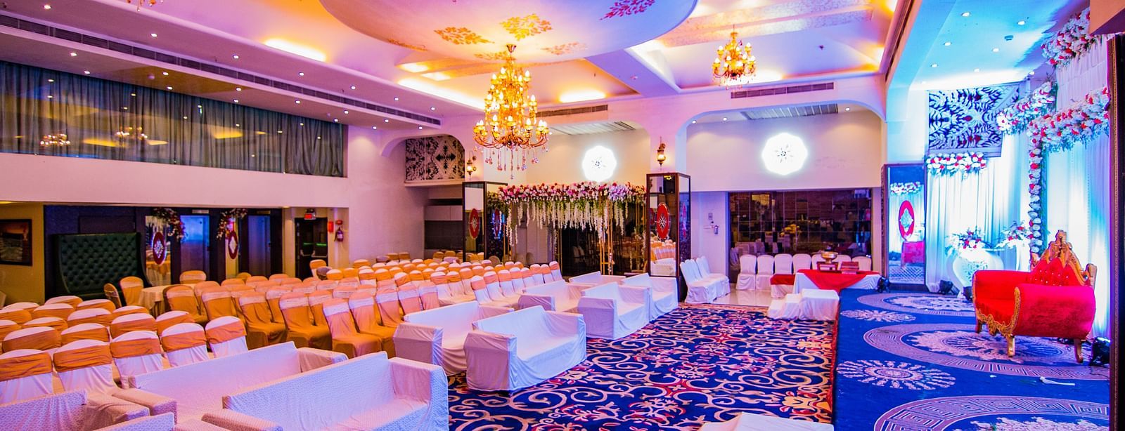 Kohinoor highlighting the stage area and rows of chairs facing the stage.
