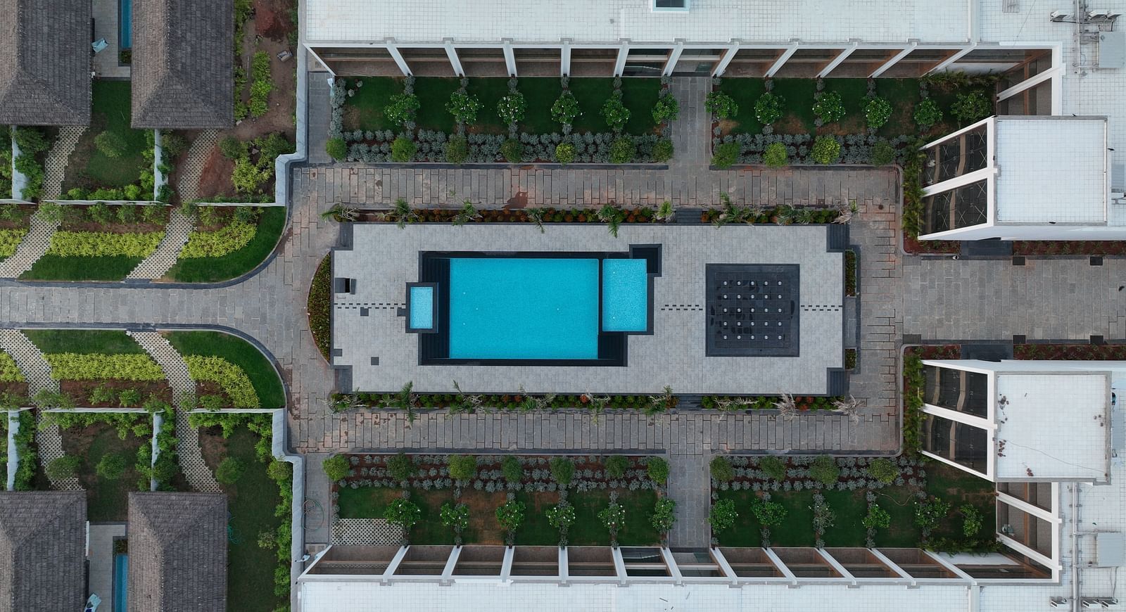 A top angle shot of The Shore Trishvam, Pondicherry featuring a swimming pool surrounded by the resort buildings.