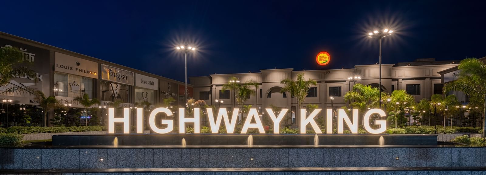 Exterior view of Hotel Highway King, Kishangarh with bright Highway King signage and lit-up facade at night.