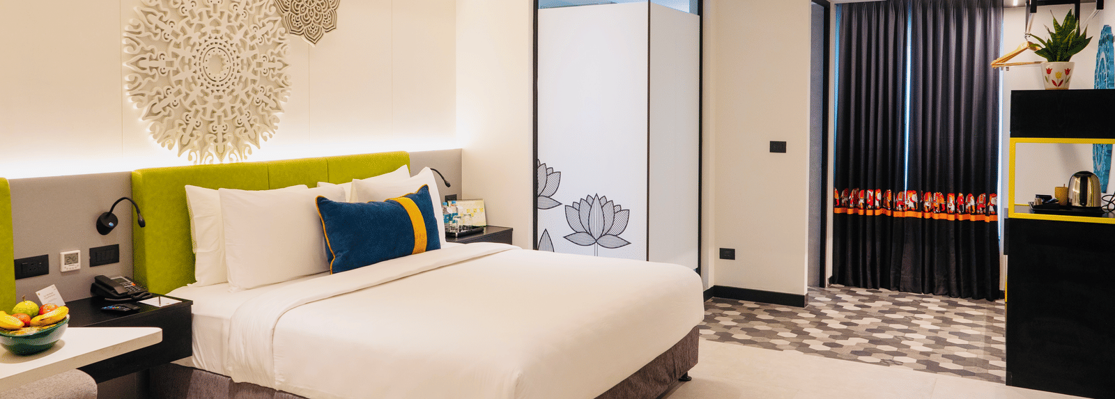 A bedroom showcasing a sculptured headboard at Zibe Luxe Kakinada by GRT Hotels that provide luxury rooms in Kakinada.