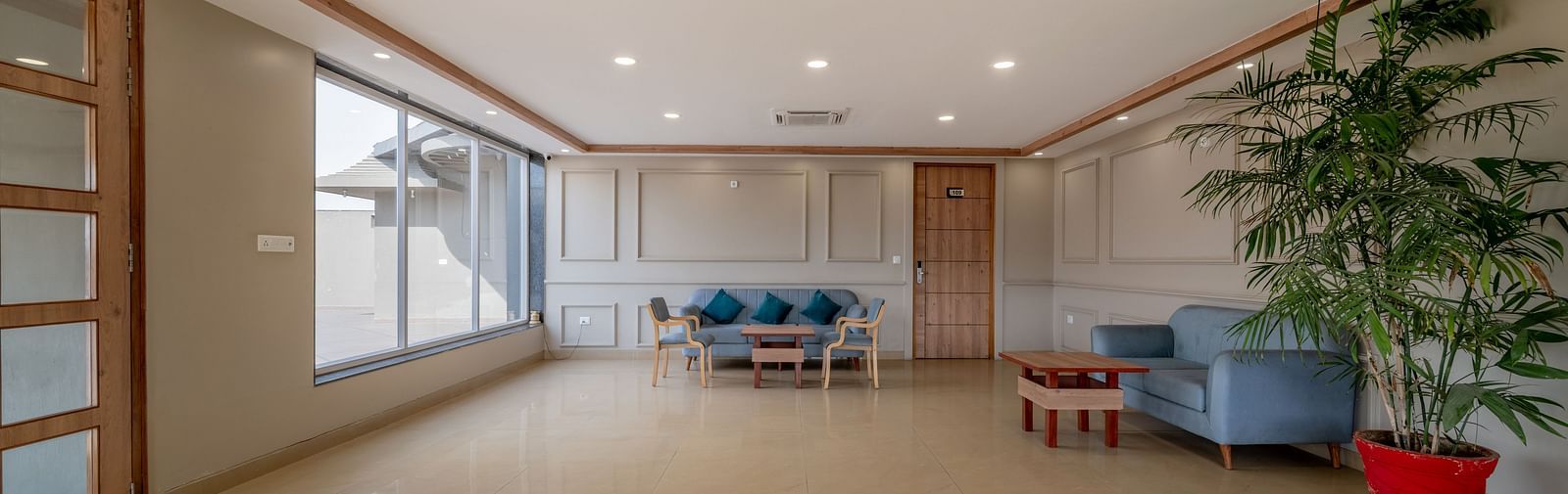 A spacious and well-lit indoor common area with minimalist decor at Hotel Highway King Shahpura.