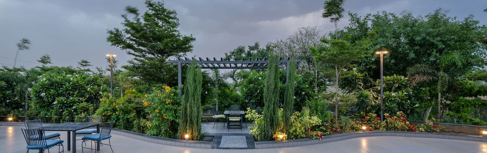A serene landscape showcasing the blue swimming pool and landscaped gardens at Hotel Highway King Shahpura.