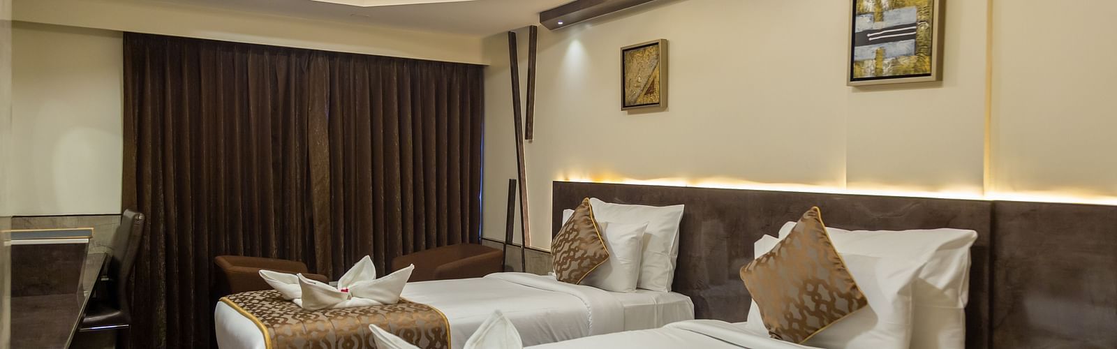 a bedroom with two single beds and overhead lighting - Hotel Park Elanza, Chennai