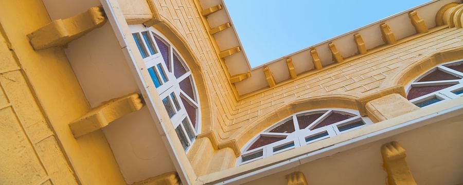 Close up shot of a yellow building with white window panes at The Garden Ananta Elite. 