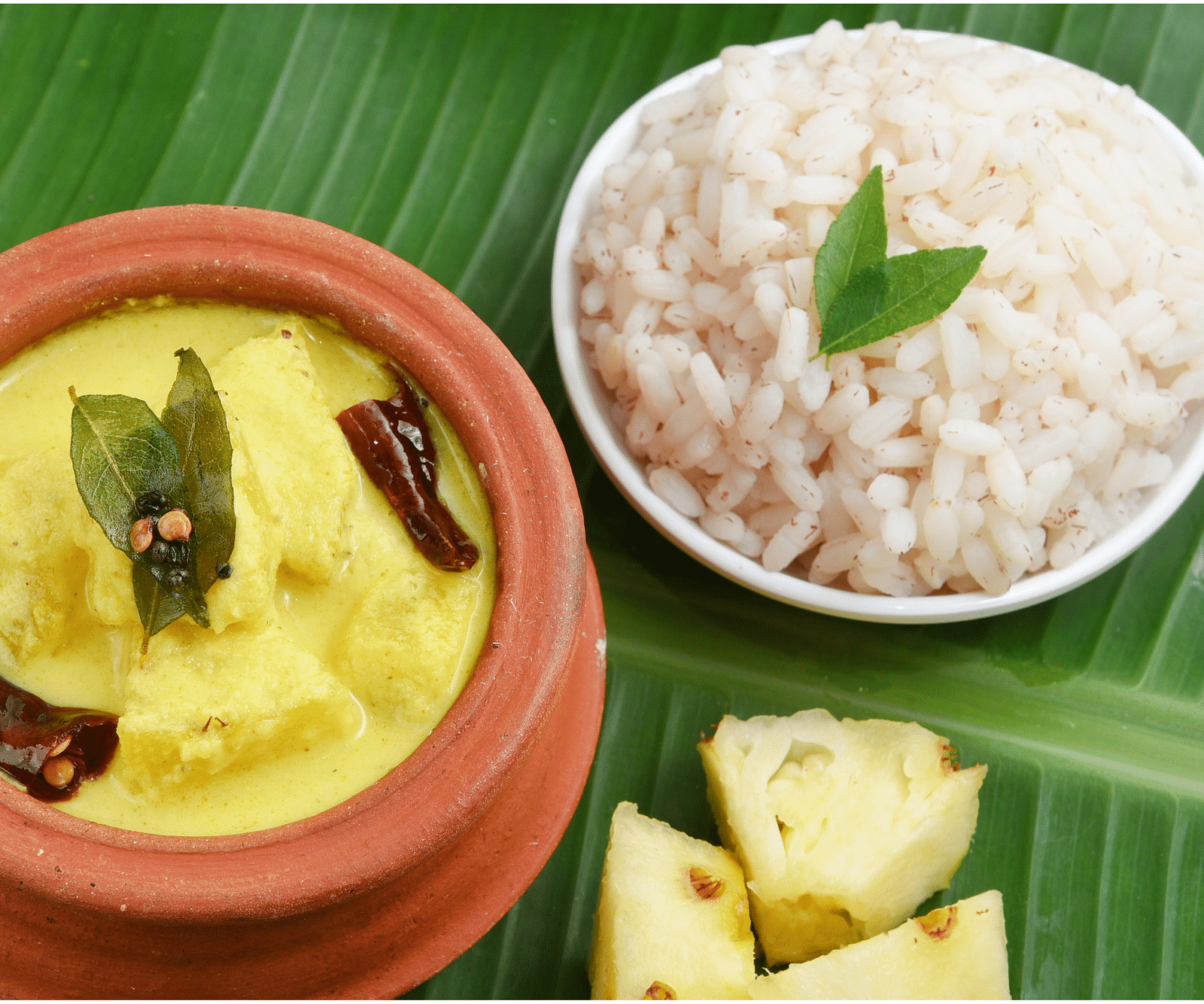 an image of a close up shot of rice and curry kept in a plate and pot - Rhythm Kumarakom
