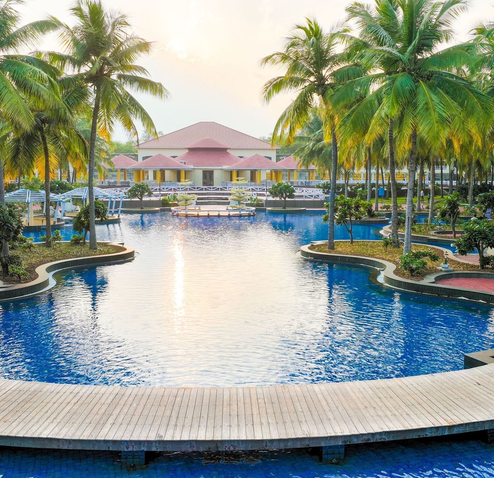 Swimming pool surrounded by coconut trees at Ocean Spray, Pondicherry