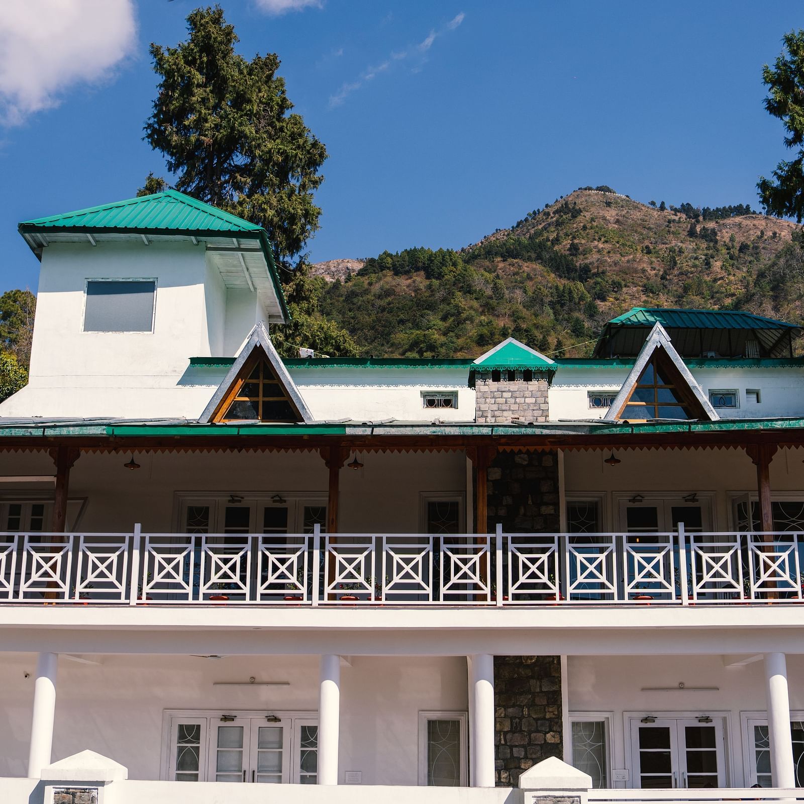 Facade of BluSalzz Villas - The Green Roof, Bhimtal, is set against a stunning backdrop of mountains and lush trees.