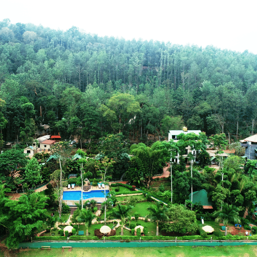 Aerial view of Coorg Jungle Camp Backwater Resort, Kushalnagar surround by lush greenery.