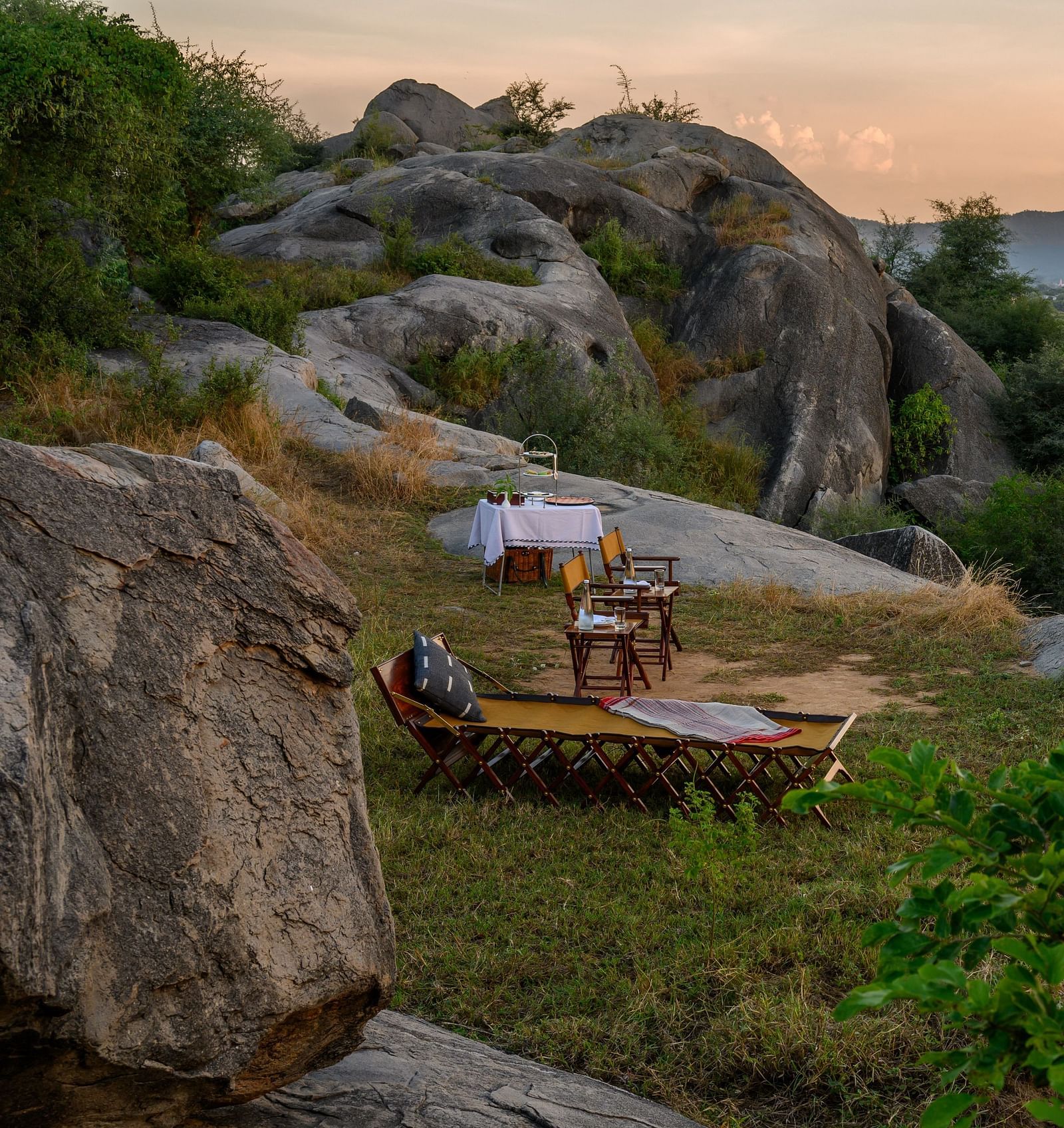 An image of an outdoor seating on top of a hill amidst greenery over viewing the mountains - Utsav Camp Sariska