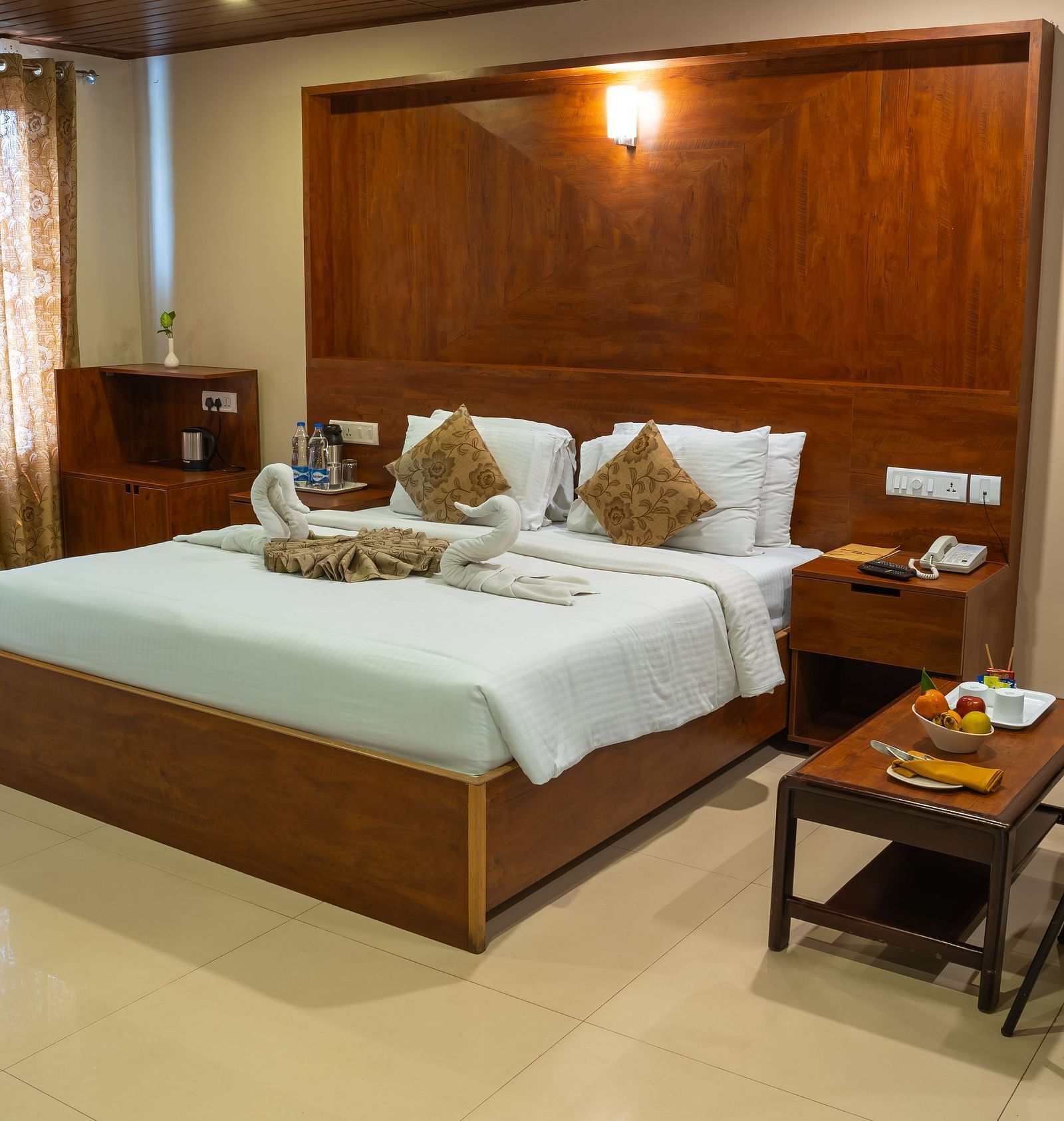 Superior Room includes a king size bed, a wooden headboard, and a sitting area | Woodstock Resorts, Coorg