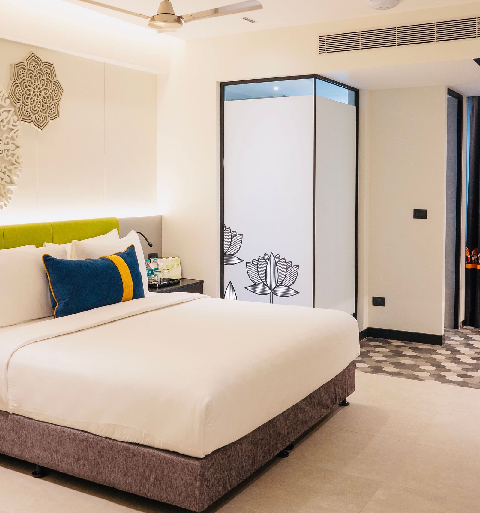 An image of a bedroom showcasing a sculptured headboard at Zibe Luxe Kakinada by GRT Hotels