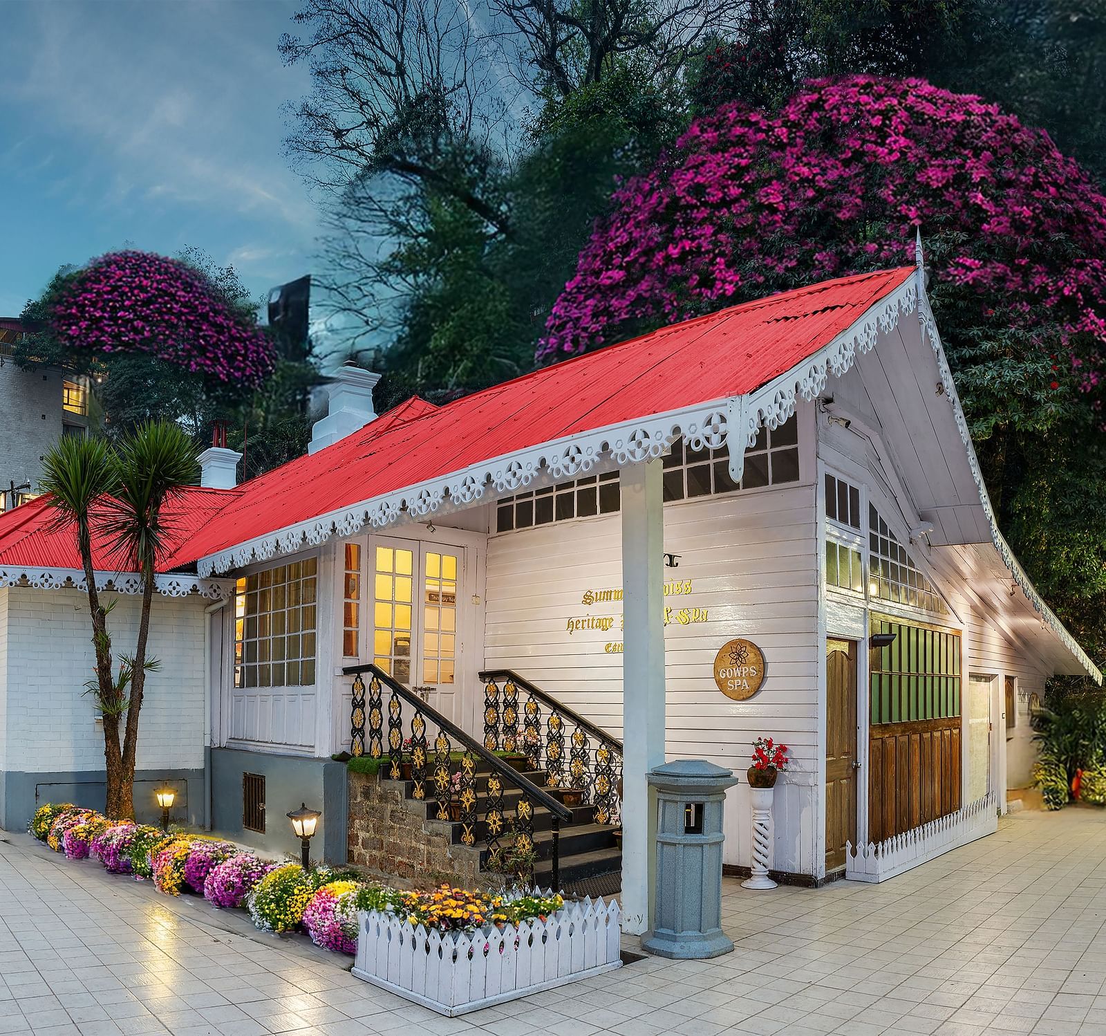 Facade view of Summit Swiss Heritage Resort & Spa, Mall Road, featuring the entrance, outdoor seating, and lush trees surrounding the property