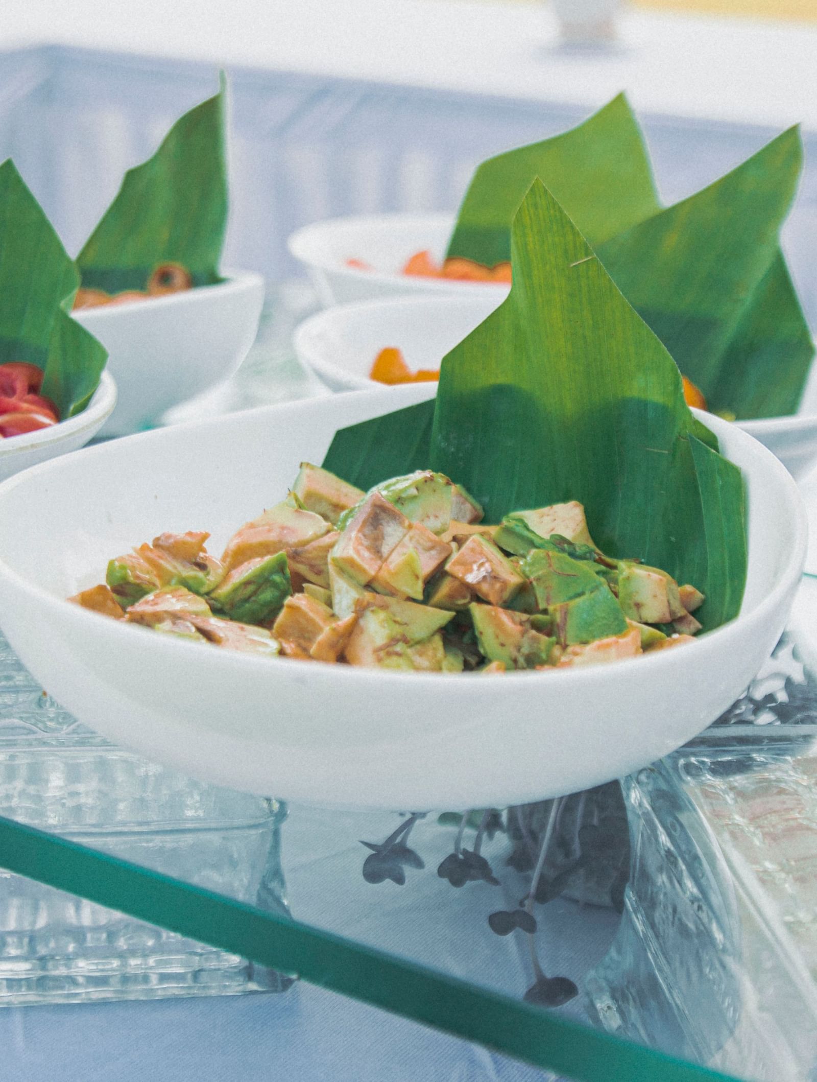 Salad counter with small bowls of prawns, greens, and olives placed on a glass buffet setup at Fireflies Resorts, Kabini.