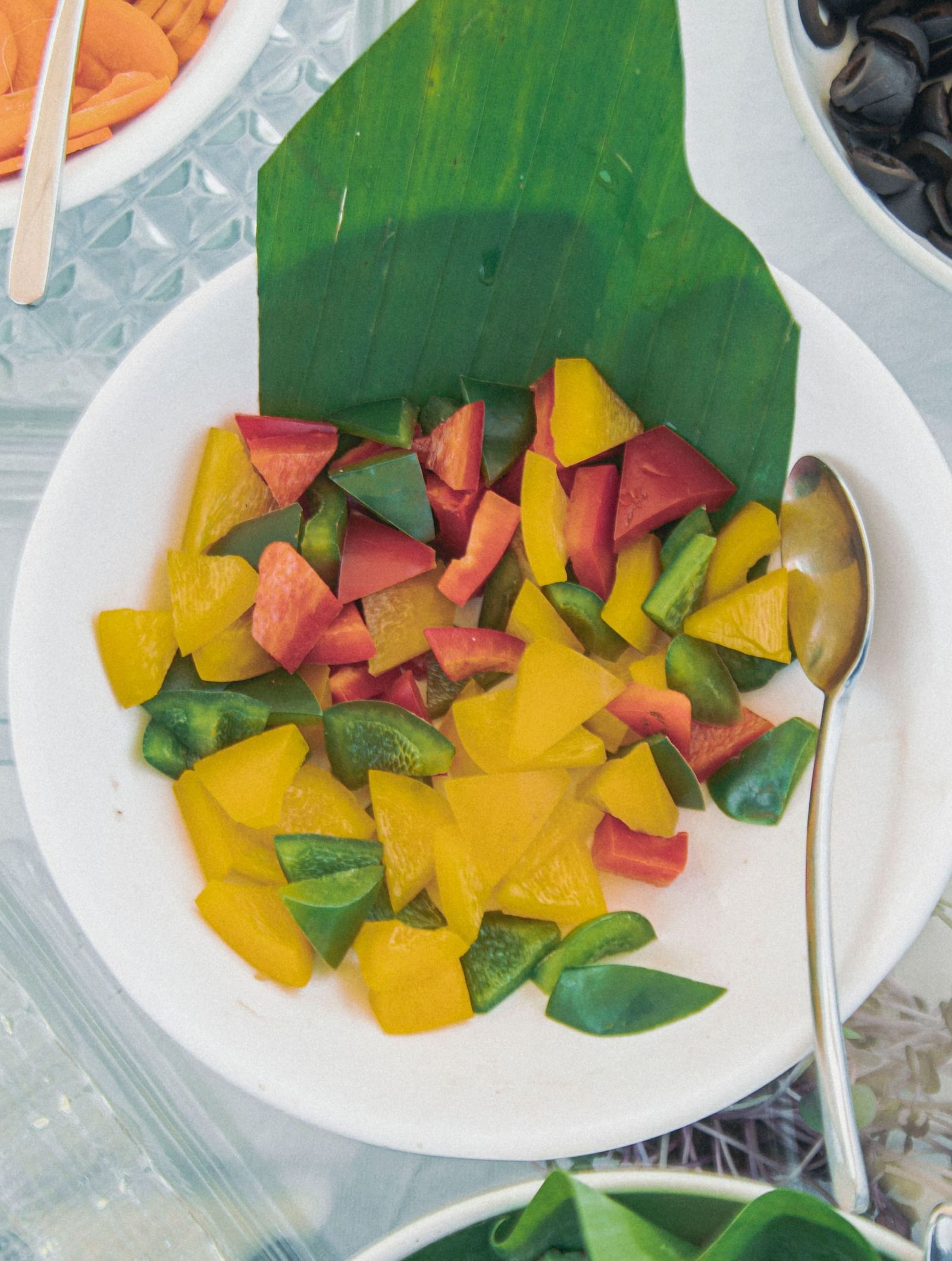Bowls of olives, diced mango, and sliced vegetables arranged neatly on a buffet counter at Fireflies Resorts, Kabini.
