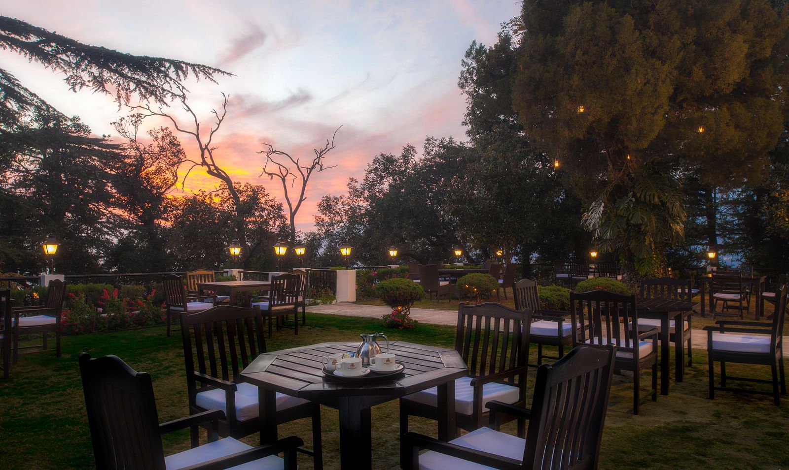 Image of an outdoor dining space in the evening at The Claridges Nabha Residence Mussoorie - Claridges Collection