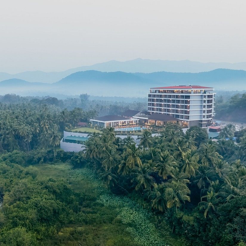 an image of aerial view of Cloud9 Sarovar Premiere, Palolem Goa surrounded by trees and mountains and water body