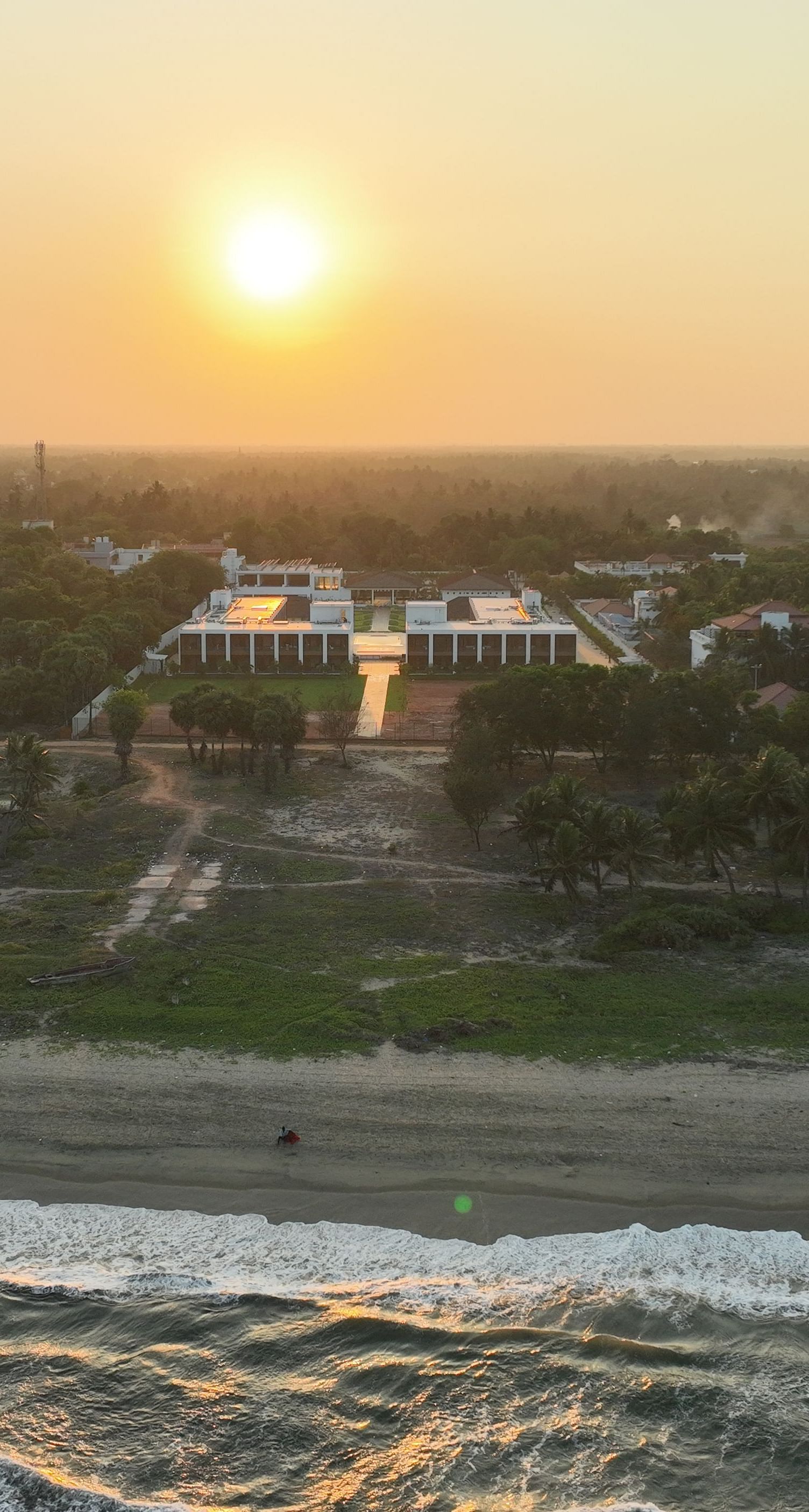 Facade image of the resort with the ocean waves crashing the beach shoreline at The Shore Trishvam, Pondicherry.