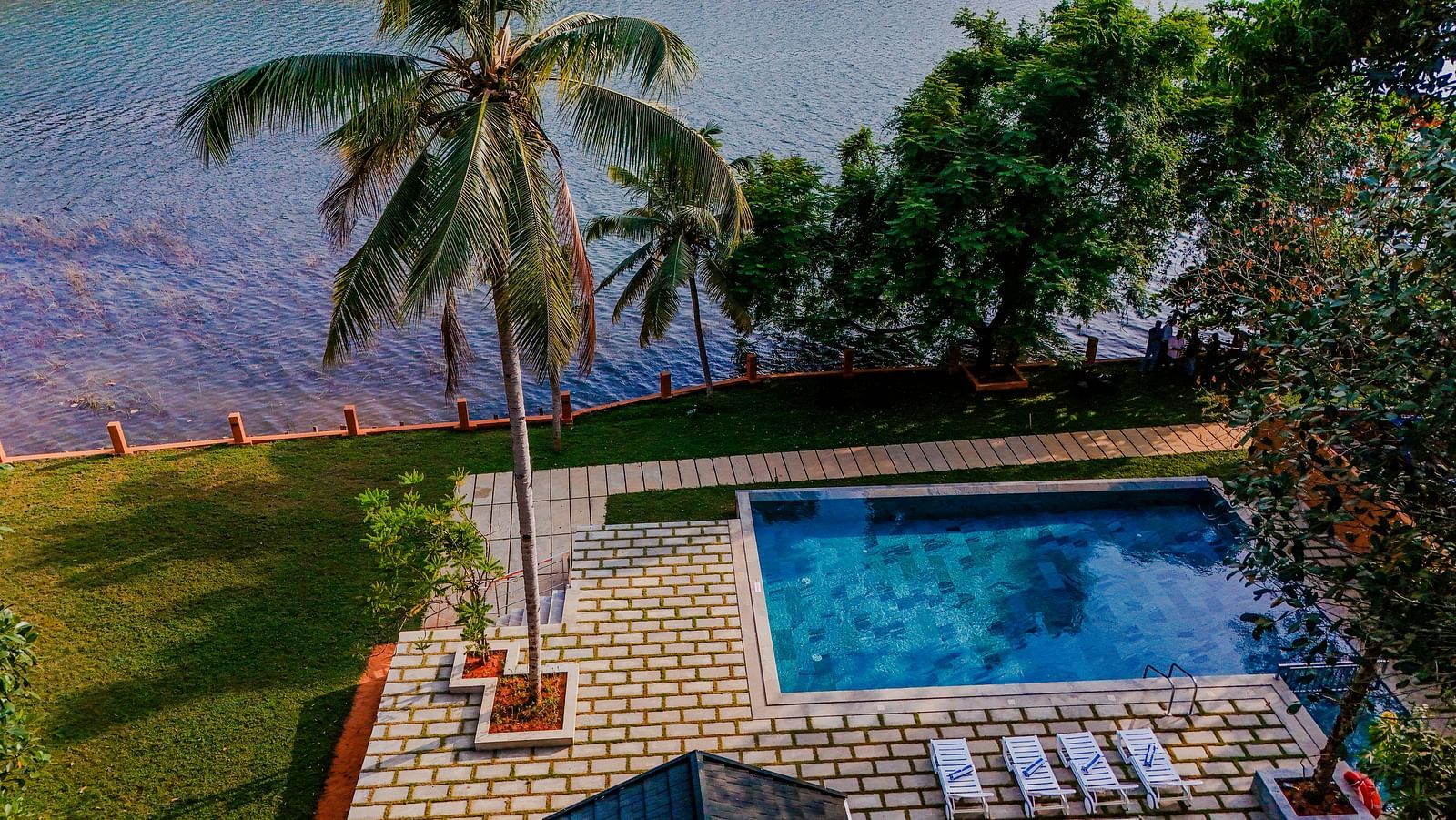 Pool area with lounge chairs and a view of the surrounding landscape.