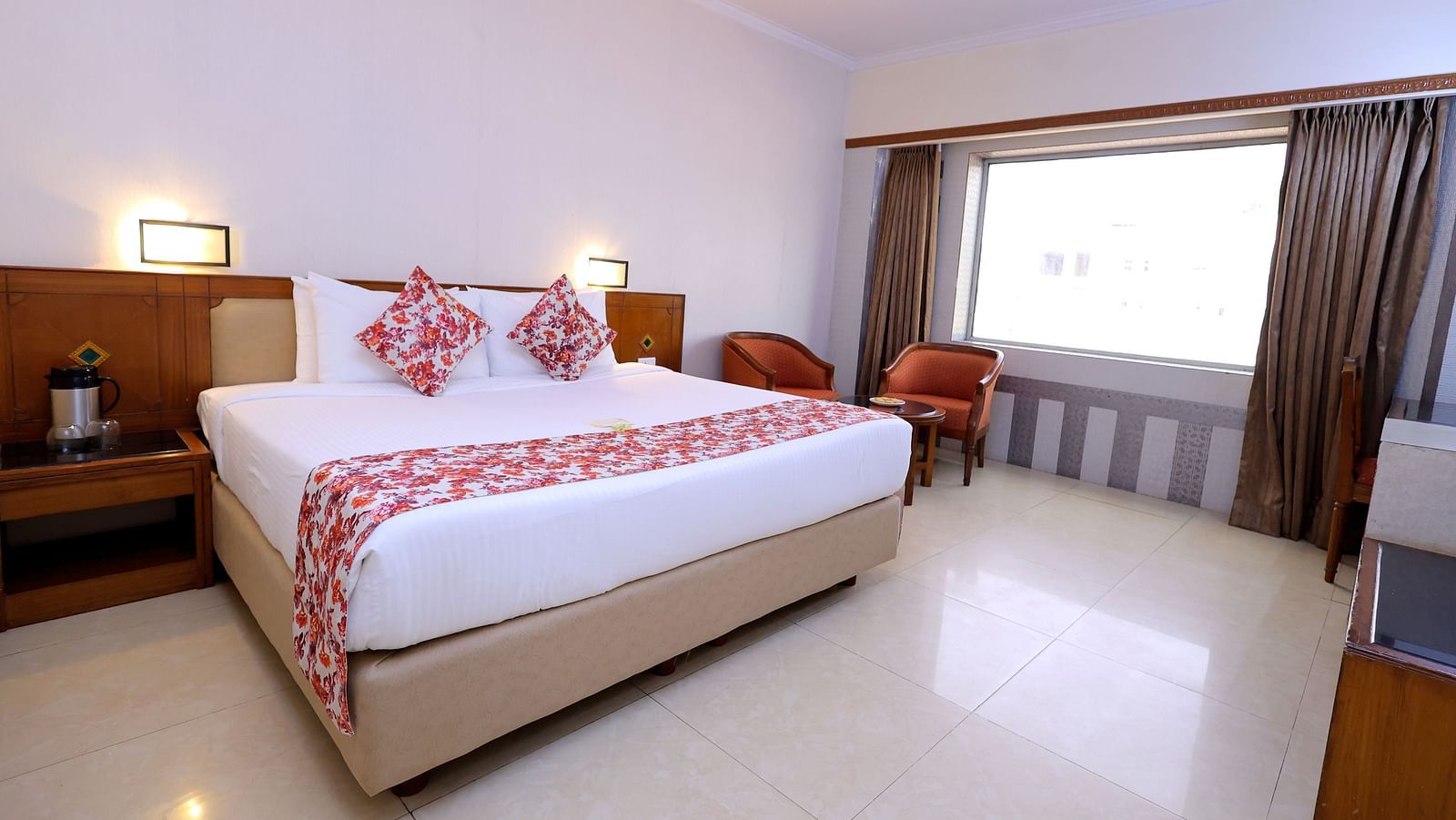 Executive room of Hotel Amar with a  bed table, TV, a big window and chairs