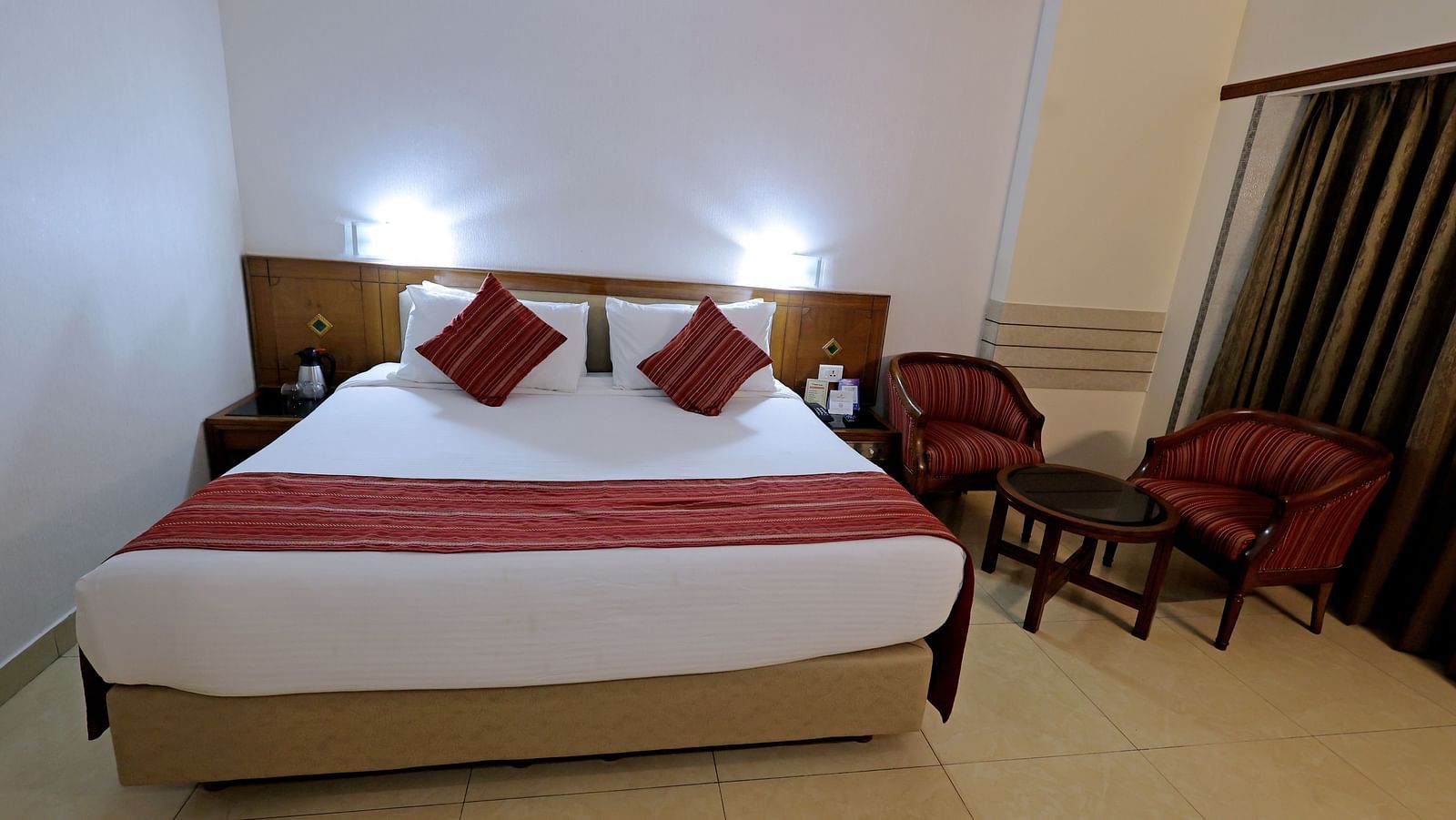 Executive room of Hotel Amar with a  bed table, TV, a big window and chairs