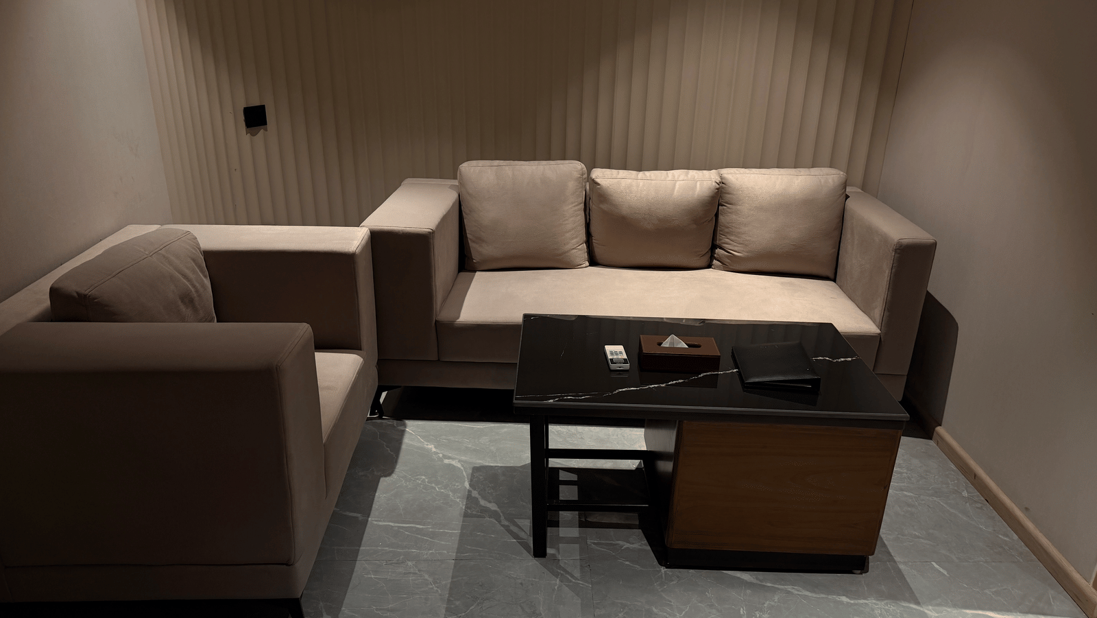 Comfortable hotel suite living area at Ramada Encore by Wyndham Gurugram Dwarka Expressway, featuring a sofa, coffee table and contemporary interiors.