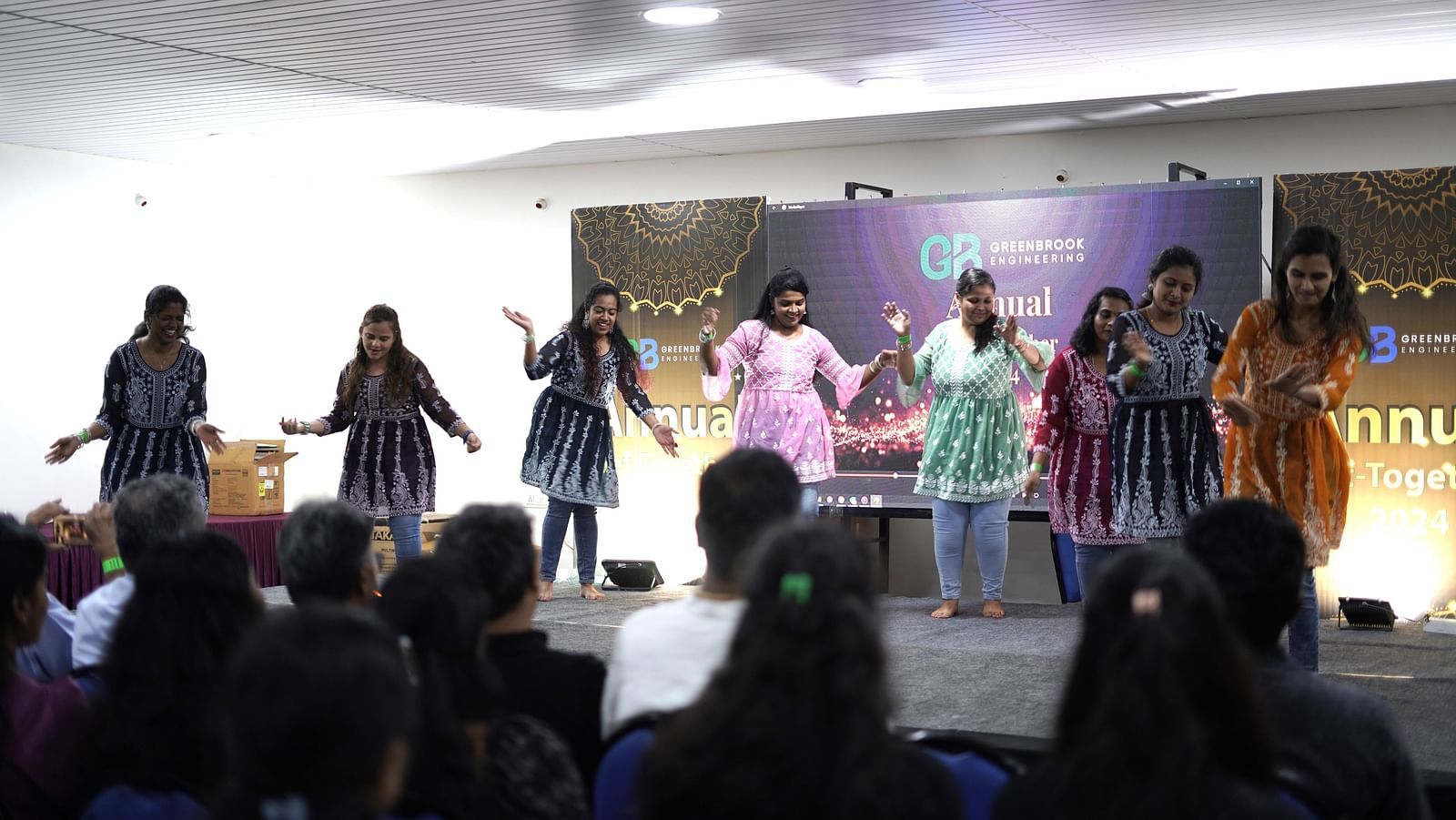 A group of ladies at Ravishing Retreat performing on the stage wearing vibrant fusion clothes