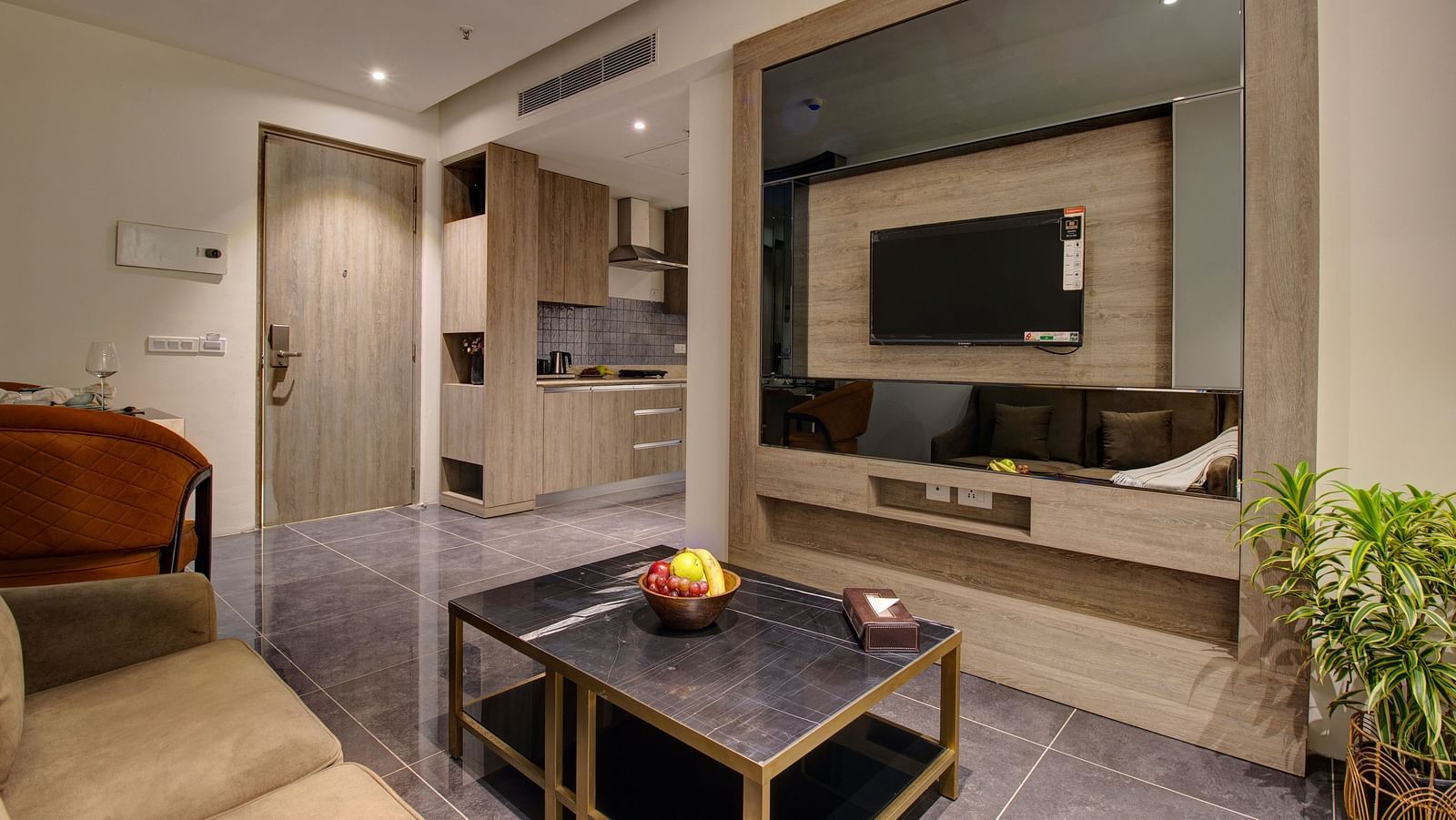 living area inside the Premium Suite with a tv wall mounted, sofas and a coffee table - Rhythm Gurugram