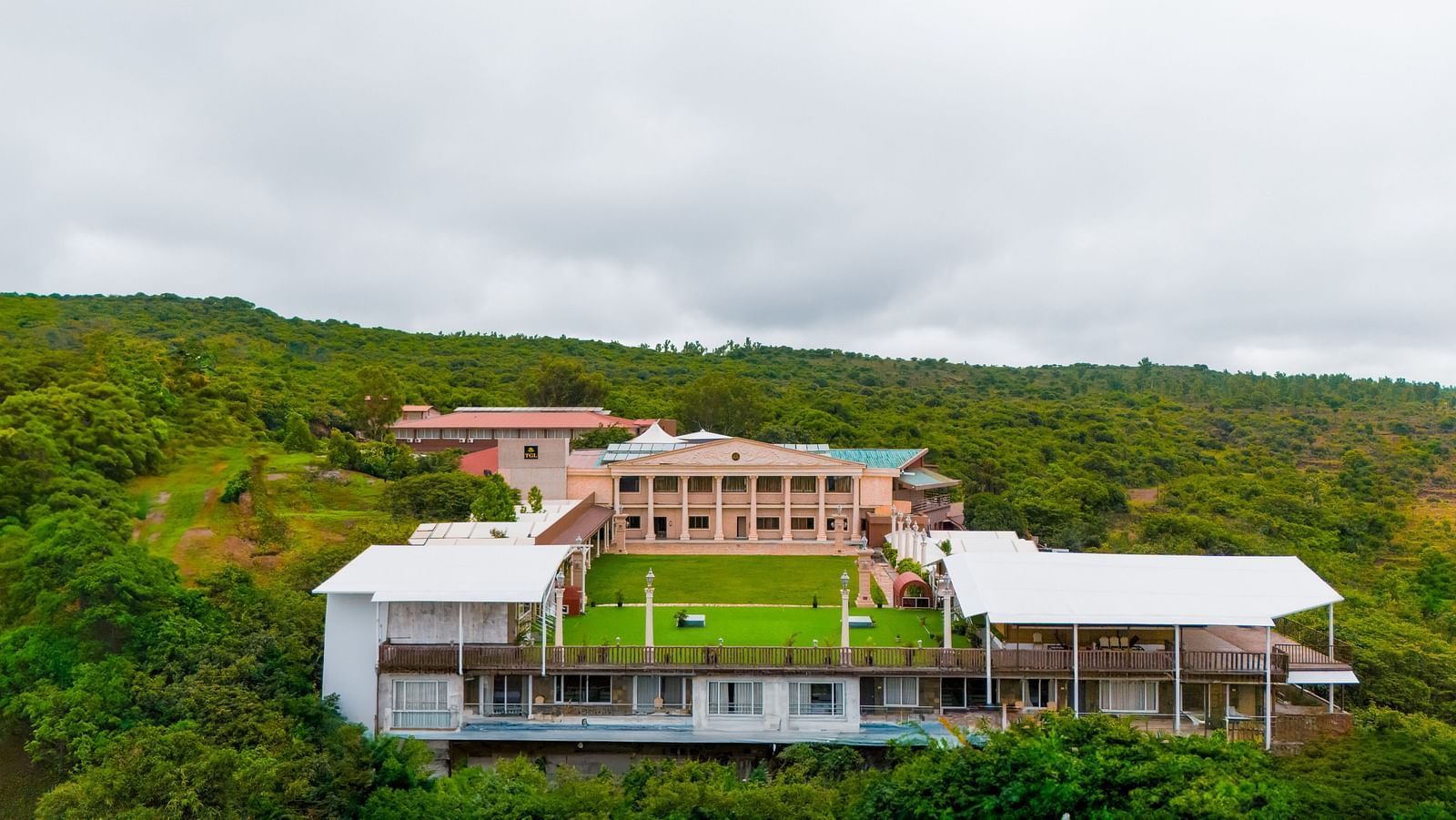 An aerial shot of the resort surrounded by mountains on all the sides | The Grand Legacy Resort and Spa