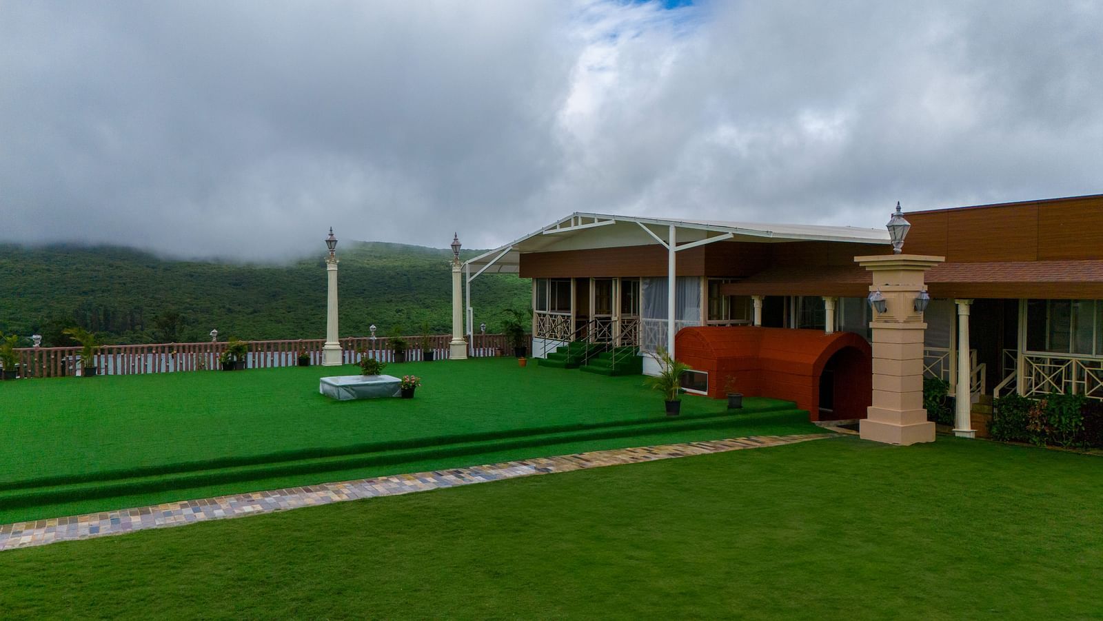 Shot of the facade of the resort clicked from the lush green lawn in a different angle  during a cloudy day | The Grand Legacy Resort and Spa