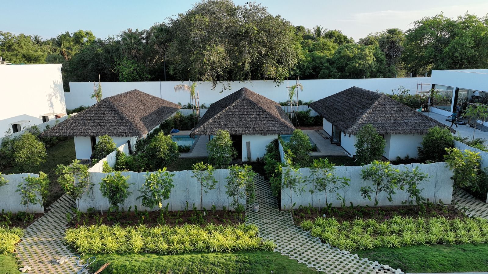 Exterior shot of three cottages with small lush green lawns in front of them at The Shore, Trishvam.