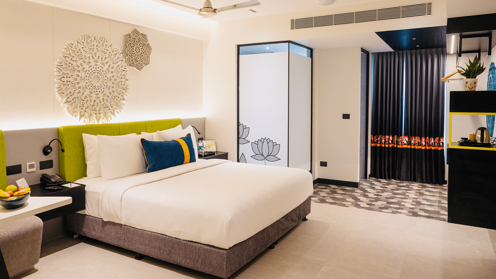 An image of a bedroom showcasing a sculptured headboard at Zibe Luxe Kakinada by GRT Hotels