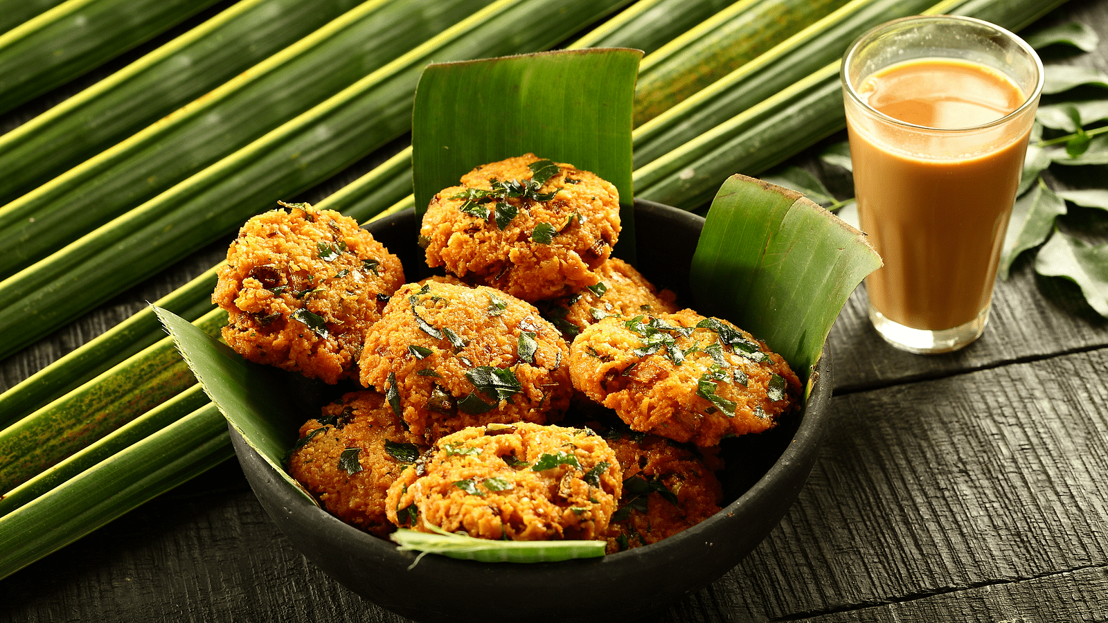 a view from above of Dal Vada and a glass of tea - Rhythm Kumarakom